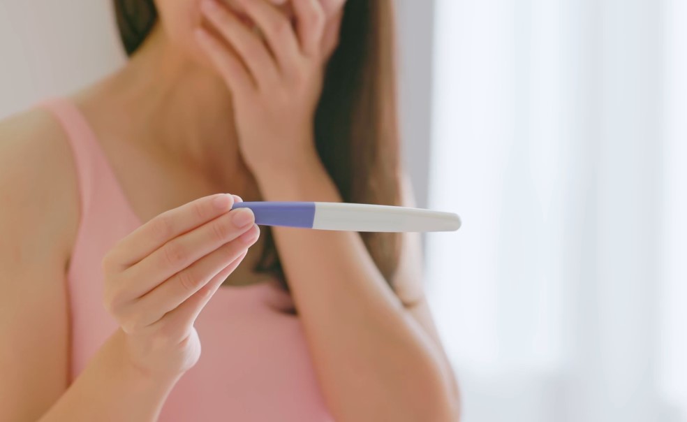 Woman looks at pregnancy test